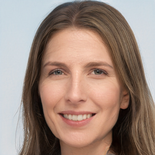 Joyful white adult female with long  brown hair and grey eyes