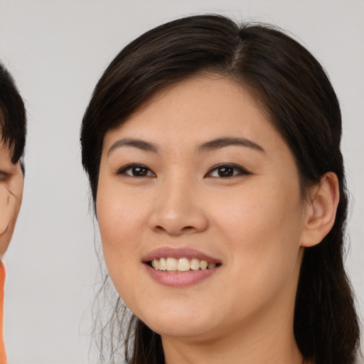 Joyful asian young-adult female with medium  brown hair and brown eyes