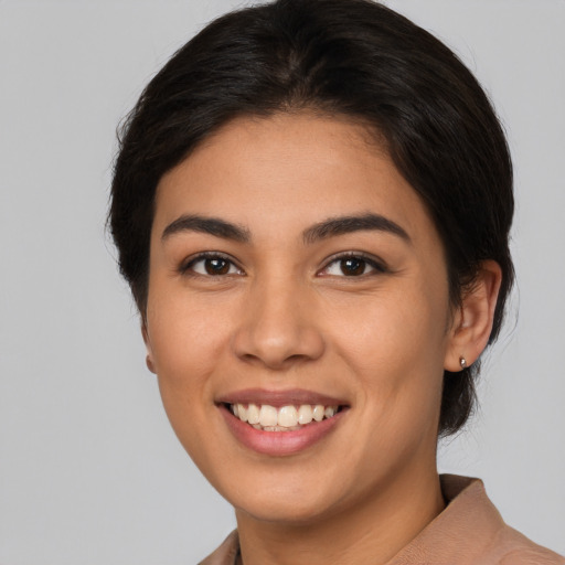 Joyful latino young-adult female with medium  brown hair and brown eyes