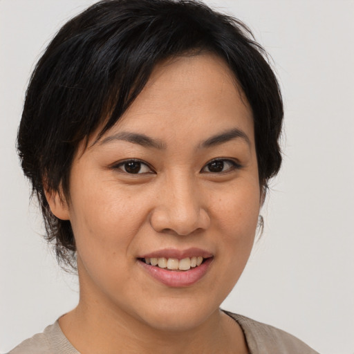Joyful asian young-adult female with medium  brown hair and brown eyes
