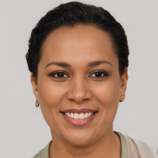 Joyful latino young-adult female with short  black hair and brown eyes