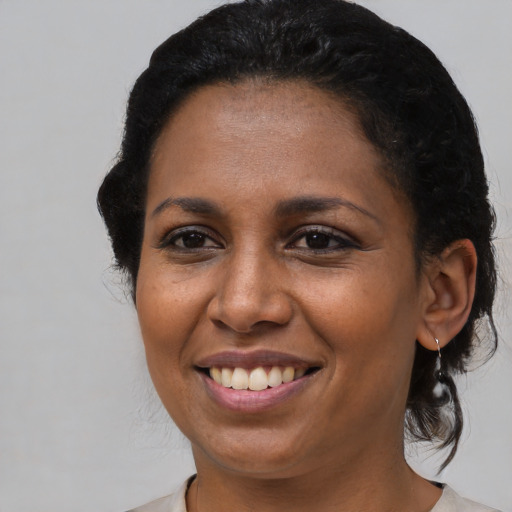 Joyful black young-adult female with medium  brown hair and brown eyes