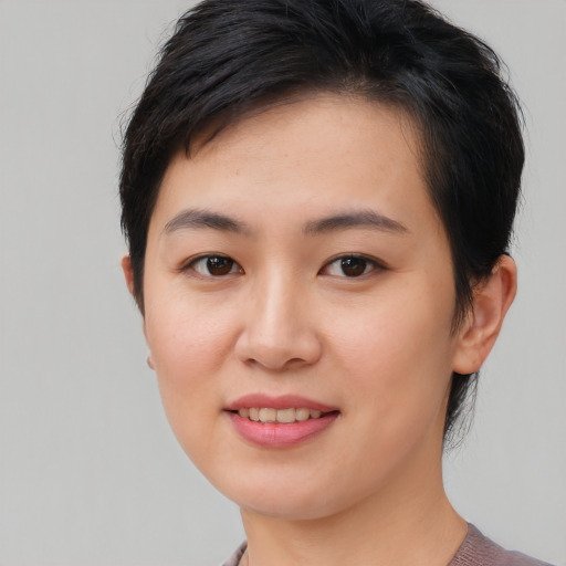 Joyful asian young-adult female with short  brown hair and brown eyes