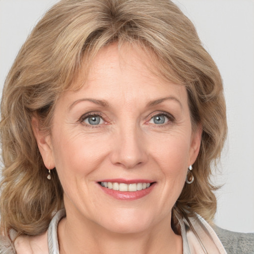 Joyful white adult female with medium  brown hair and grey eyes