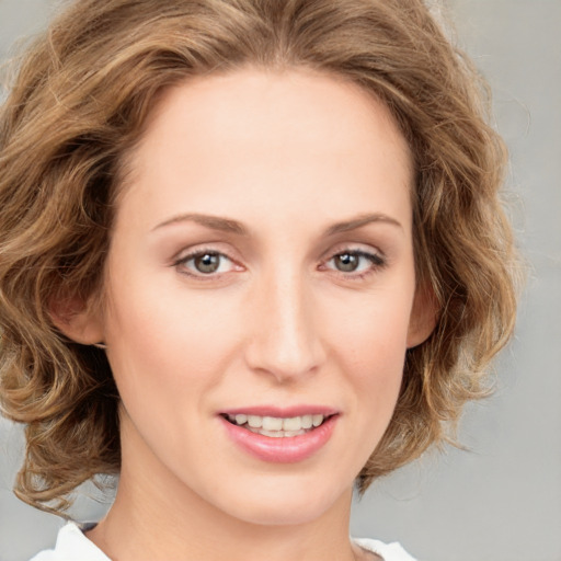 Joyful white young-adult female with medium  brown hair and green eyes