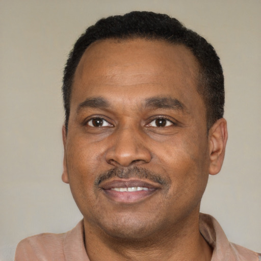 Joyful black adult male with short  brown hair and brown eyes