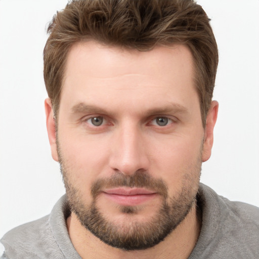 Joyful white young-adult male with short  brown hair and grey eyes