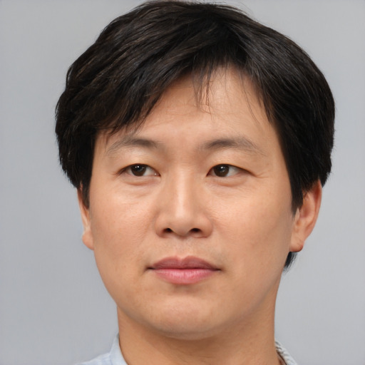 Joyful asian adult male with short  brown hair and brown eyes
