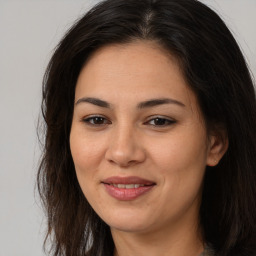 Joyful latino young-adult female with long  brown hair and brown eyes