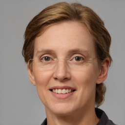 Joyful white adult female with medium  brown hair and grey eyes