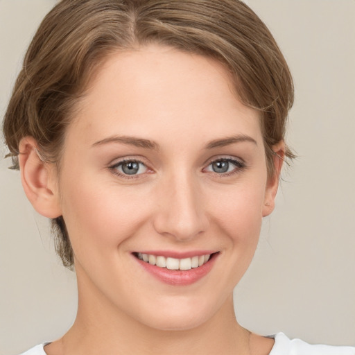 Joyful white young-adult female with medium  brown hair and grey eyes