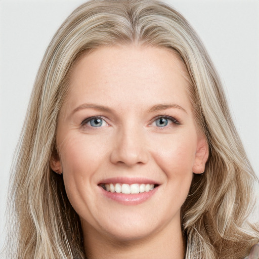 Joyful white young-adult female with long  brown hair and blue eyes