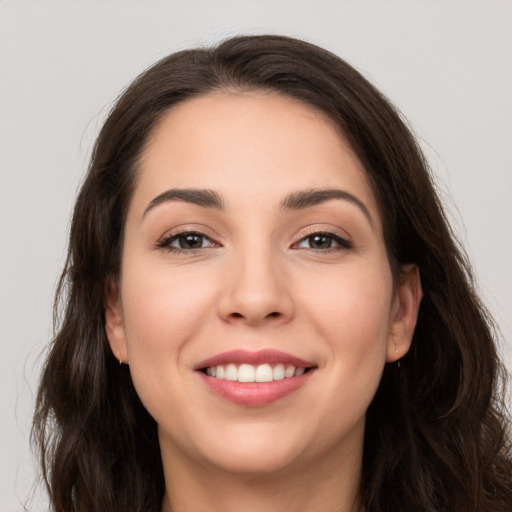 Joyful white young-adult female with long  brown hair and brown eyes