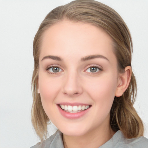 Joyful white young-adult female with medium  brown hair and blue eyes