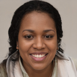 Joyful black young-adult female with long  brown hair and brown eyes