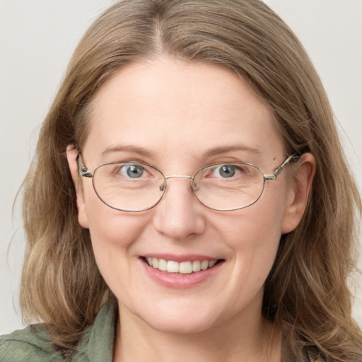 Joyful white adult female with long  brown hair and blue eyes