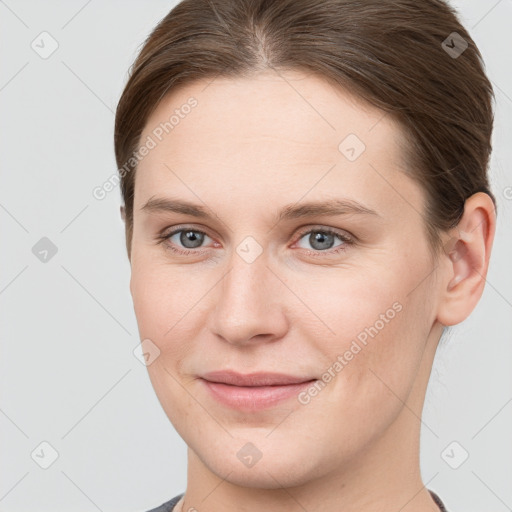 Joyful white young-adult female with short  brown hair and grey eyes