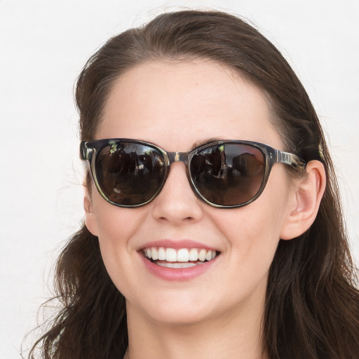 Joyful white young-adult female with long  brown hair and blue eyes