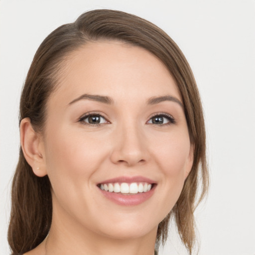 Joyful white young-adult female with medium  brown hair and grey eyes