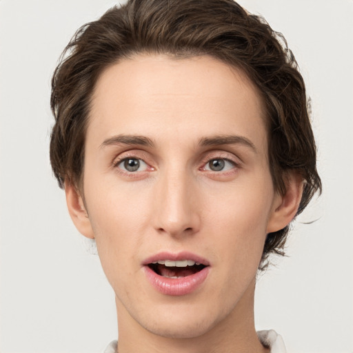 Joyful white young-adult male with short  brown hair and green eyes