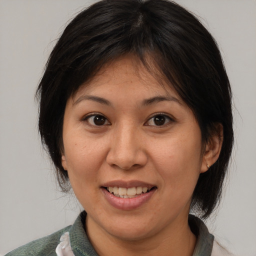 Joyful asian adult female with medium  brown hair and brown eyes