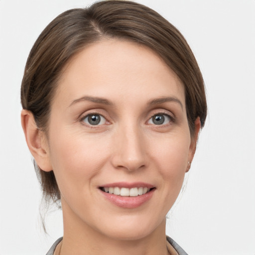 Joyful white young-adult female with medium  brown hair and grey eyes