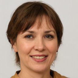 Joyful white adult female with medium  brown hair and grey eyes