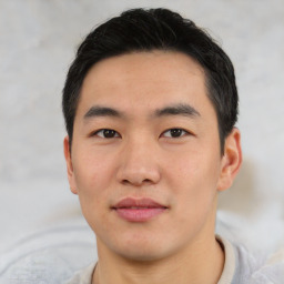 Joyful asian young-adult male with short  black hair and brown eyes