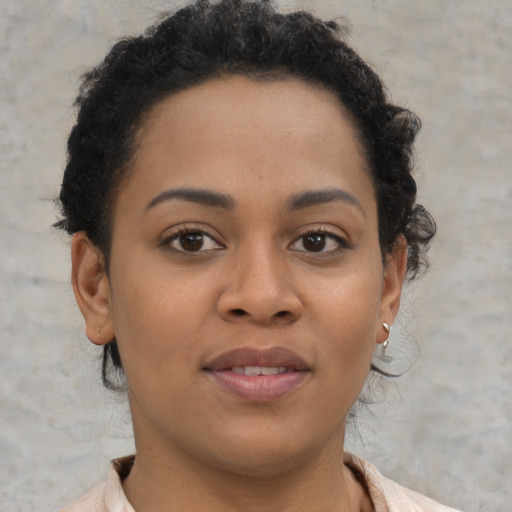 Joyful black young-adult female with short  brown hair and brown eyes