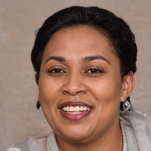 Joyful latino adult female with short  brown hair and brown eyes