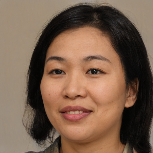 Joyful asian young-adult female with medium  brown hair and brown eyes