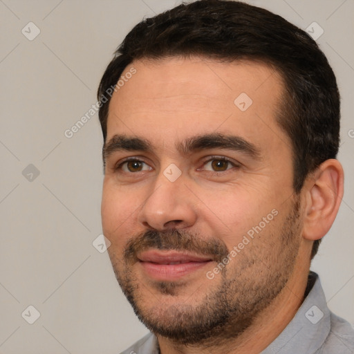 Joyful white adult male with short  black hair and brown eyes