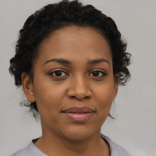 Joyful black young-adult female with short  brown hair and brown eyes