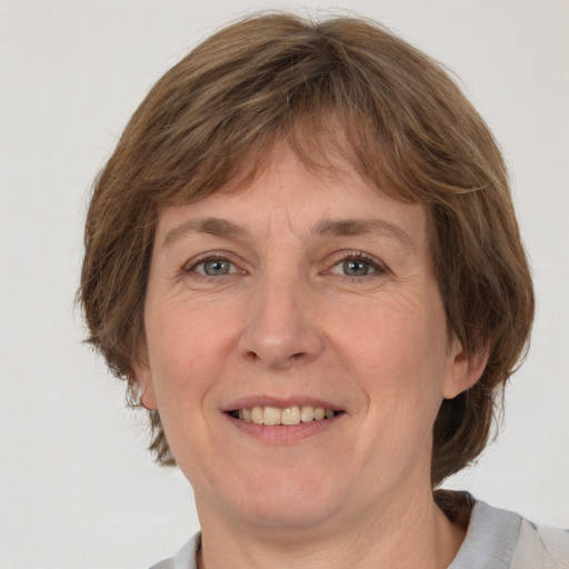 Joyful white adult female with medium  brown hair and grey eyes