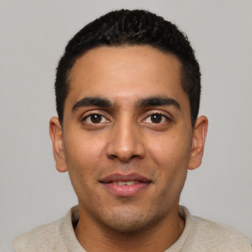 Joyful latino young-adult male with short  black hair and brown eyes