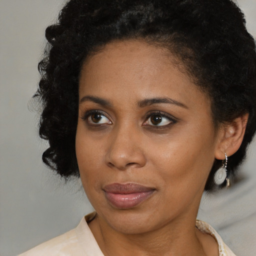 Joyful black young-adult female with medium  brown hair and brown eyes
