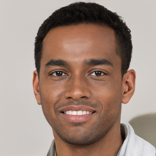 Joyful black young-adult male with short  black hair and brown eyes