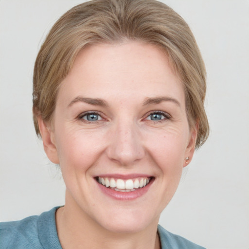 Joyful white young-adult female with short  brown hair and blue eyes