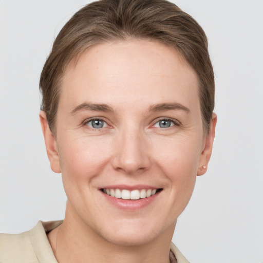 Joyful white young-adult female with short  brown hair and grey eyes