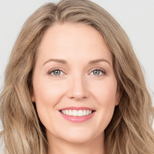 Joyful white young-adult female with long  brown hair and green eyes