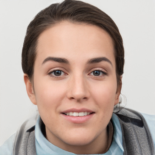 Joyful white young-adult female with short  brown hair and grey eyes