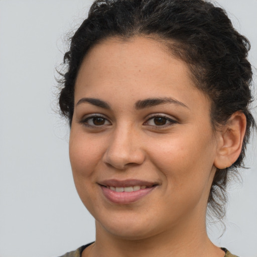 Joyful latino young-adult female with medium  brown hair and brown eyes