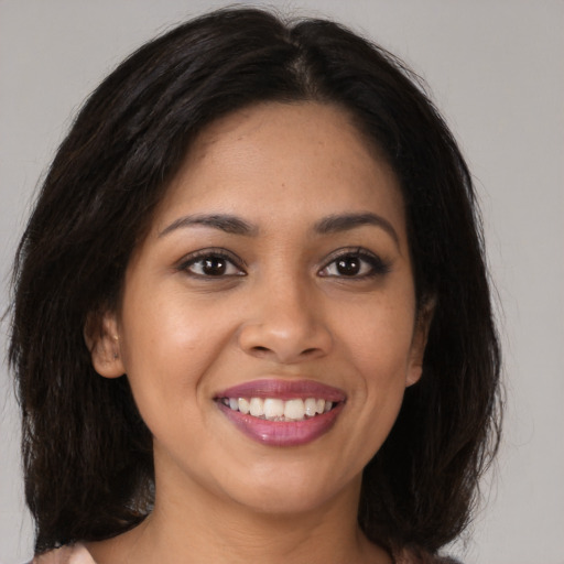 Joyful latino young-adult female with long  brown hair and brown eyes