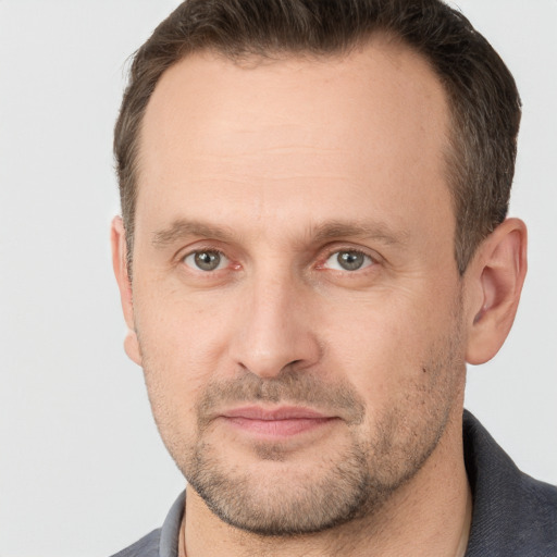 Joyful white adult male with short  brown hair and grey eyes