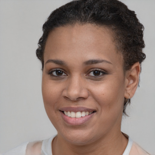 Joyful black young-adult female with short  brown hair and brown eyes