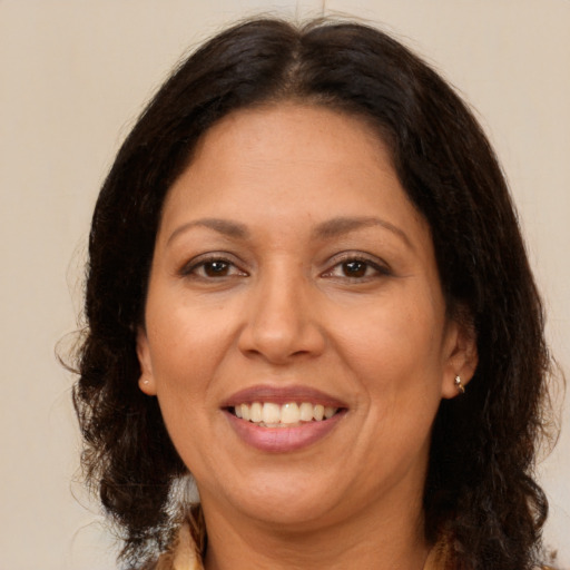 Joyful latino adult female with long  brown hair and brown eyes