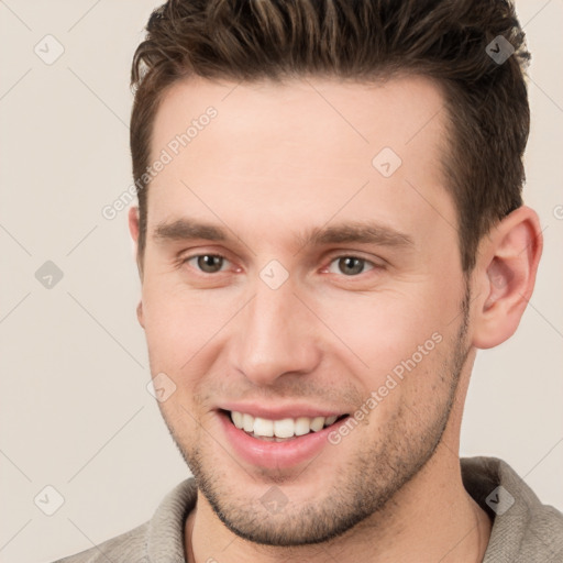 Joyful white young-adult male with short  brown hair and brown eyes