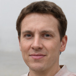 Joyful white adult male with short  brown hair and grey eyes