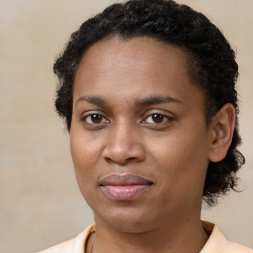 Joyful black young-adult female with short  brown hair and brown eyes