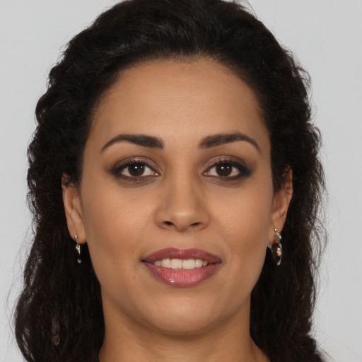 Joyful latino young-adult female with long  brown hair and brown eyes